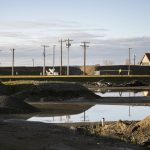 Piles of fill dirt are reflected in puddles at the Port of Everett on Monday, Dec. 9, 2024 in Everett, Washington. (Olivia Vanni / The Herald)