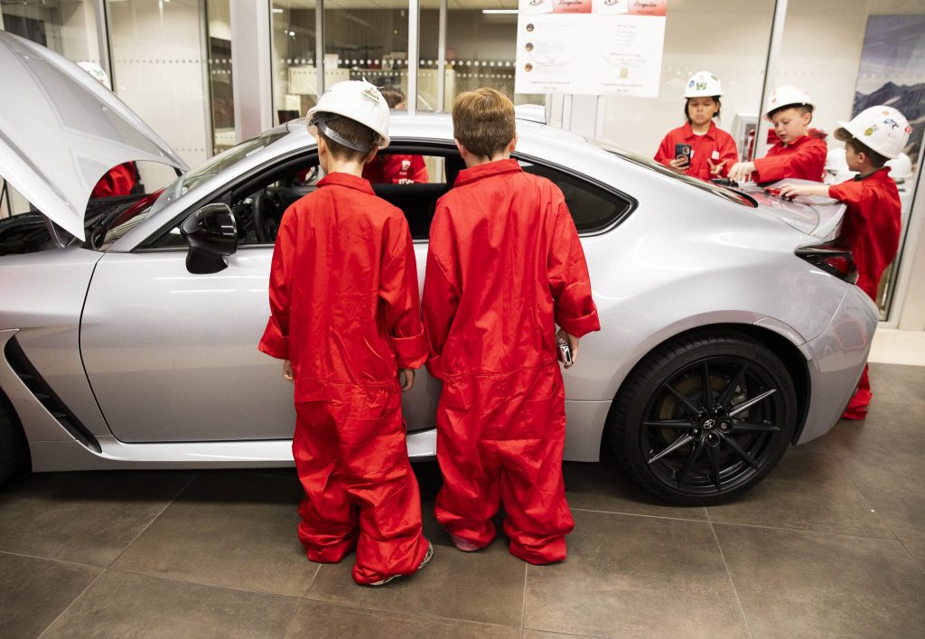 Local Boys & Girls Club children look at a life size model of the miniature car they built during Toyota Mini Makers Garage on Monday, Dec. 9, 2024 in Marysville, Washington. (Olivia Vanni / The Herald)
