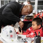 Alan Williams, left, helps Coen Sportsman, 8, secure the chassis of his miniature car during Toyota Mini Makers Garage hosted by Marysville Toyota and Toyota Lexus Minority Owners Dealership Association on Monday, Dec. 9, 2024 in Marysville, Washington. (Olivia Vanni / The Herald)