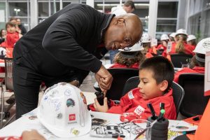 Alan Williams, left, helps Coen Sportsman, 8, secure the chassis of his miniature car during Toyota Mini Makers Garage hosted by Marysville Toyota and Toyota Lexus Minority Owners Dealership Association on Monday, Dec. 9, 2024 in Marysville, Washington. (Olivia Vanni / The Herald)