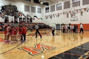 Stanwood (red) and Monroe (white) each huddle before a league game at Monroe High School on Dec. 7, 2024. (Qasim Ali / The Herald)