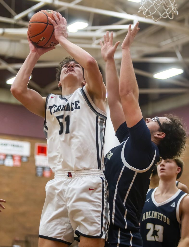 Mountlake Terraces Oliver Shaw-Jones tries to make a layup while being guarded during the game against Arlington on Tuesday, Dec. 10, 2024 in Mountlake Terrace, Washington. (Olivia Vanni / The Herald)