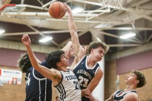 Mountlake Terrace and Arlington players all leap in the air for a rebound during the game on Tuesday, Dec. 10, 2024 in Mountlake Terrace, Washington. (Olivia Vanni / The Herald)