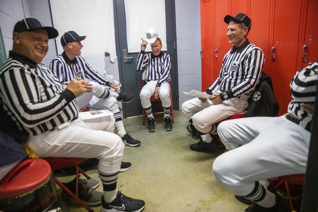 Ross Noe (left to right), Steve Jensen, Tom Freal, Jim Brotten and Dean Corcoran all laugh in the locker room as they get ready to officiate a high school football game on Friday, Oct. 4, 2024 in Snohomish, Washington. (Olivia Vanni / The Herald)