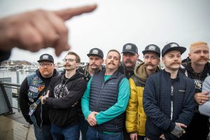 Dozens of people with mustaches clipped wait to be measured for a Guinness World Record Mustache Chain Attempt on Friday, Nov. 1, 2024 in Everett, Washington. (Olivia Vanni / The Herald)