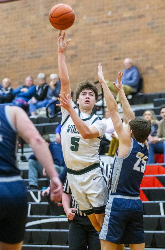 Jacksons Joey Gosline tries to pass the ball to a teammate while being guarded during the game against Squalicum on Friday, Dec. 27, 2024 in Mountlake Terrace, Washington. (Olivia Vanni / The Herald)