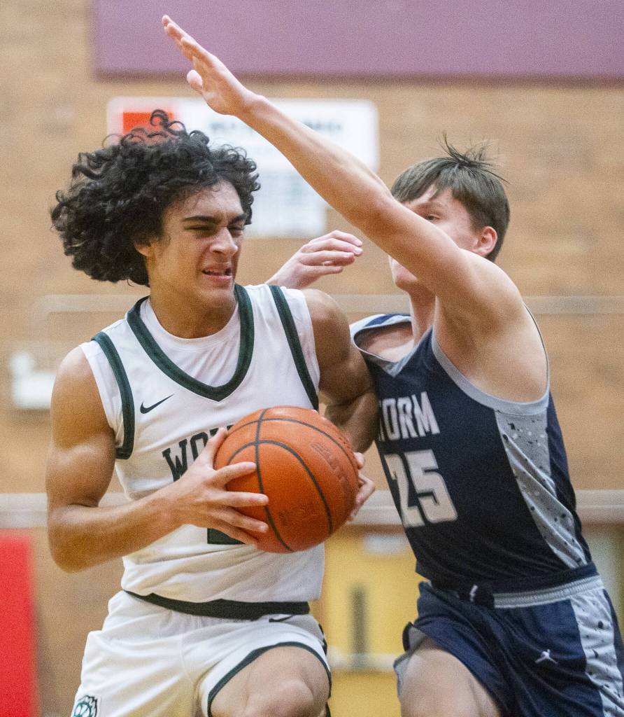 Jacksons Seamus Williams grimaces as he tries to maneuver around a Squalicum player during the game on Friday, Dec. 27, 2024 in Mountlake Terrace, Washington. (Olivia Vanni / The Herald)