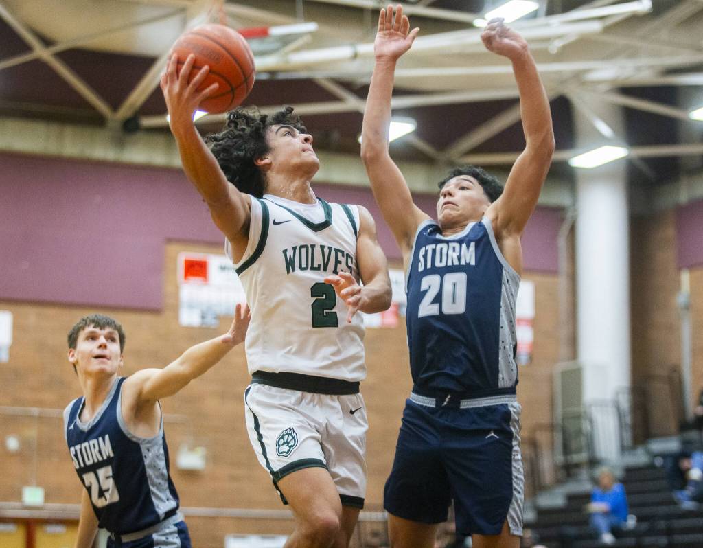 Jacksons Seamus Williams reaches around for a layup during the game against Squalicum on Friday, Dec. 27, 2024 in Mountlake Terrace, Washington. (Olivia Vanni / The Herald)