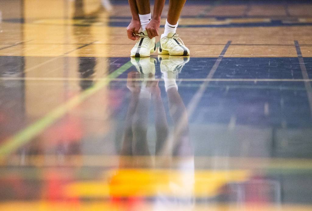 Shorecrests Robel Biniam ties his shoes before shooting a free-throw during the game against Cascade on Monday, Dec. 30, 2024 in Shoreline, Washington. (Olivia Vanni / The Herald)