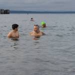 Chris Oliver, center, looks at his 11-year-old son, Jay, as the two swim in the cold water after taking the plunge on Wednesday, Jan. 1 in Edmonds, Washington (Will Geschke / The Herald)