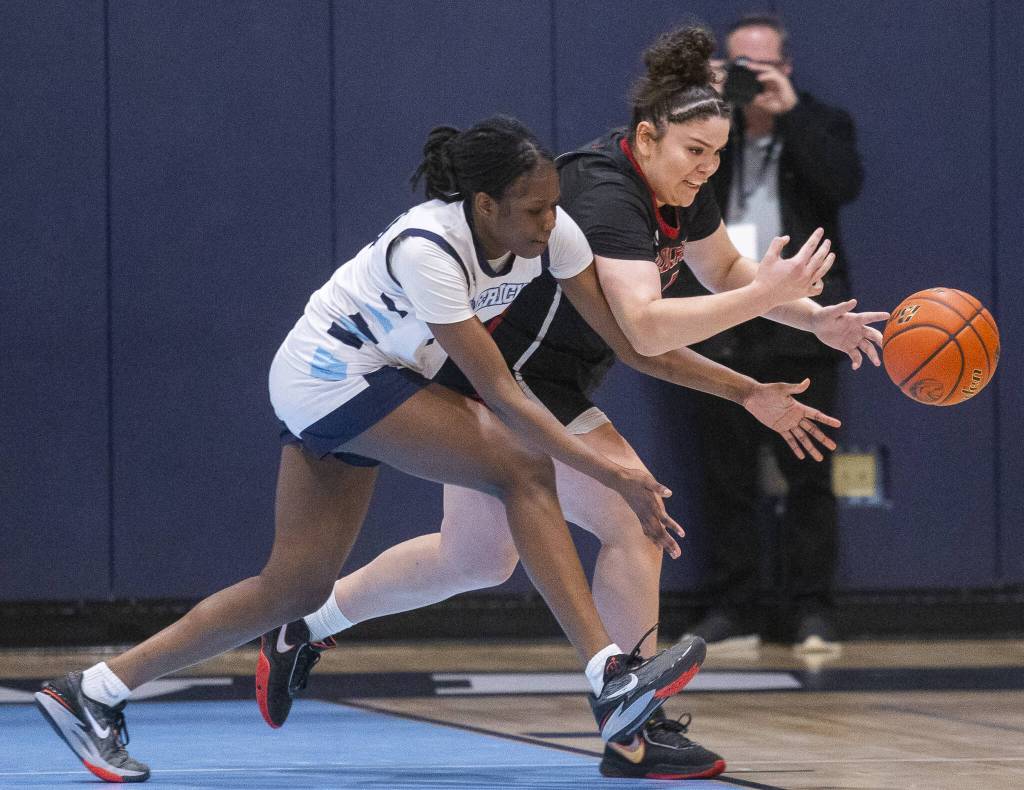 Meadowdales Lisa Sonko and Archbishop Murphys Celine Wright both run after a loose ball during the game on Friday, Jan. 3, 2025 in Lynnwood, Washington. (Olivia Vanni / The Herald)