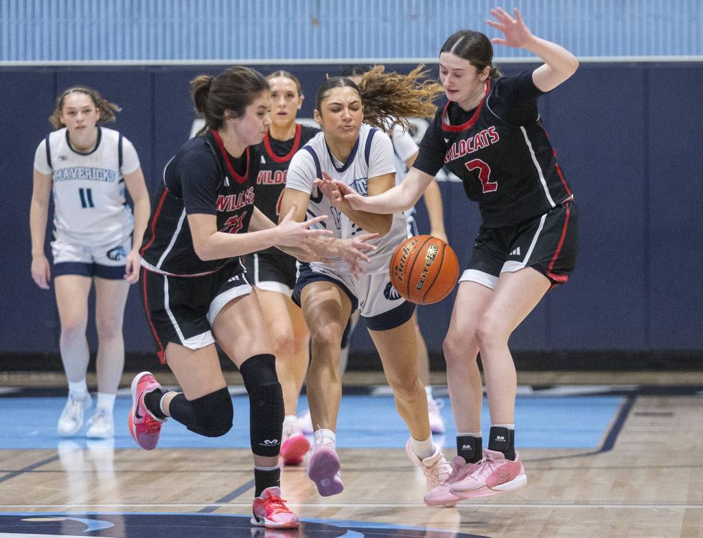 Meadowdales Kaiya Dotter scrambles for a close ball with Archbishop Murphys Ava Marr and Brooke Blachly during the game on Friday, Jan. 3, 2025 in Lynnwood, Washington. (Olivia Vanni / The Herald)