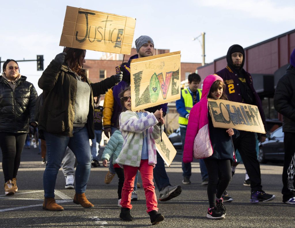 Lillian Lewis, 5, center, holds a sign with Love written on the front while she walks in an annual Martin Luther King Jr. Day march on Monday, Jan. 20, 2025 in Everett, Washington. (Olivia Vanni / The Herald)
