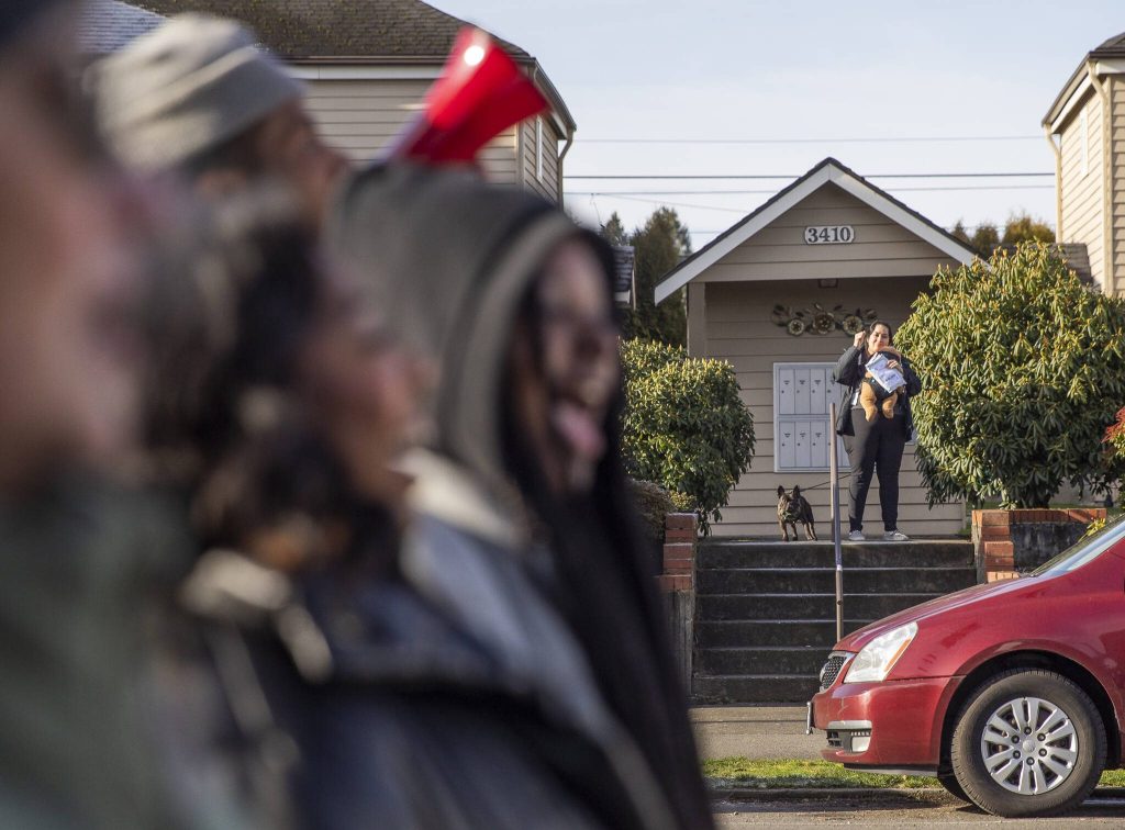 A person lifts a fist in support of those walking down Colby Avenue in an annual Martin Luther King Jr. Day march on Monday, Jan. 20, 2025 in Everett, Washington. (Olivia Vanni / The Herald)