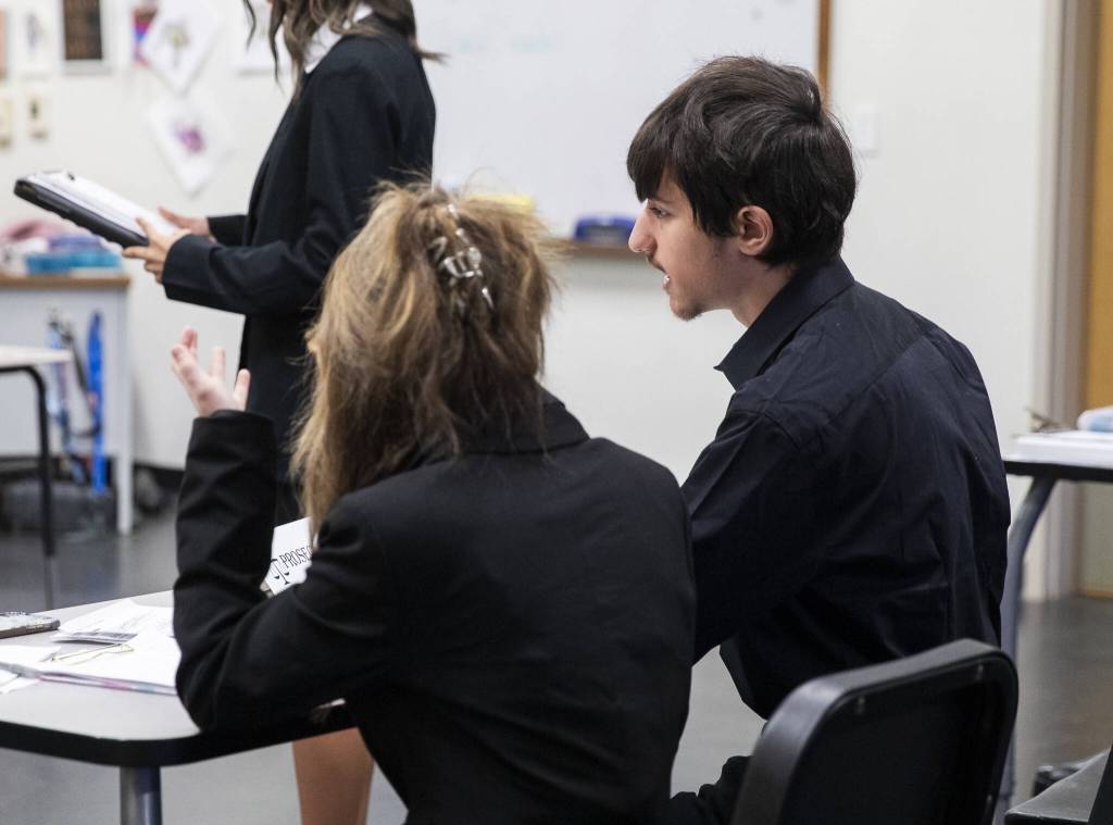 Braedon Bracero talks with his co-council as the defense cross-examines the witness during a mock trial at 10th Street Middle School on Friday, Jan. 10, 2025, in Marysville, Washington. (Olivia Vanni / The Herald)