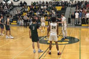 Edmonds-Woodway boys basketball (green) and Shorecrest (white) prepare for tipoff ahead of a league matchup at Shorecrest High School on Jan. 8, 2025. (Qasim Ali / The Herald)
