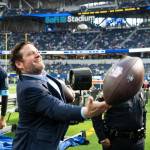 Seahawks president of football operations / general manager John Schneider tosses a football to a Seahawks fan sitting behind the Seattles bench before a game against the Los Angeles Rams at SoFi Stadium on Jan. 5, 2025. (Photo courtesy of Rod Mar / Seattle Seahawks)