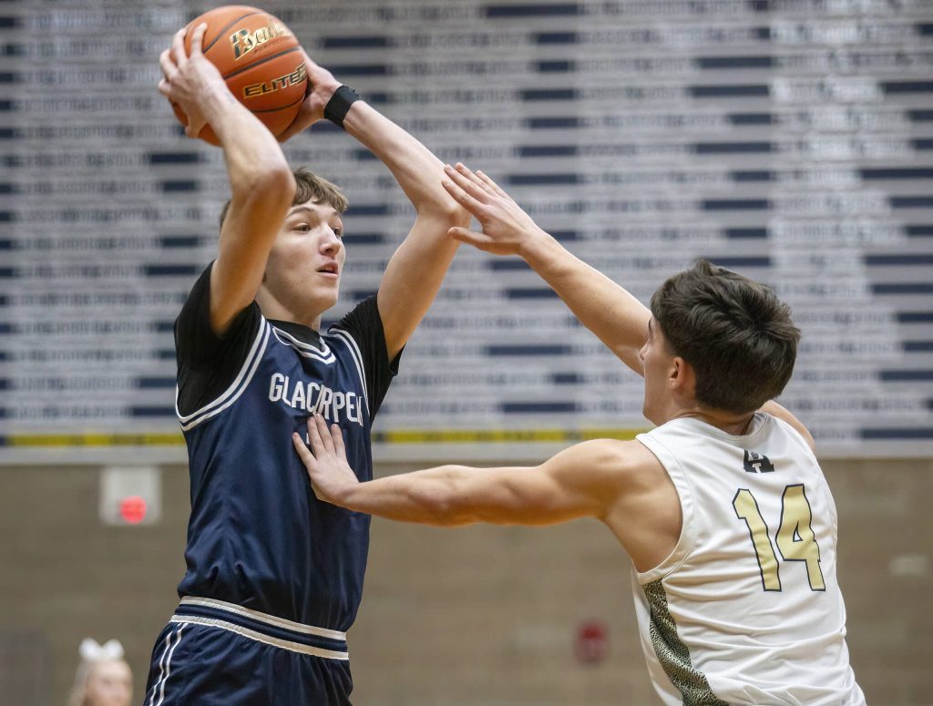 Arlingtons Jake Willis puts his hand on Glacier Peaks Jack Taylor to try and block his pass during the game on Friday, Jan. 17, 2025 in Arlington, Washington. (Olivia Vanni / The Herald)