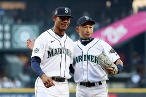The Seattle Mariners' Julio Rodriguez, left, stands with Ichiro Suzuki﻿ after Suzuki threw the ceremonial first pitch during Seattle’s home opener between the Mariners and the Houston Astros at T-Mobile Park on April 15, 2022, in Seattle. (Steph Chambers / Getty Images / Tribune News Services)