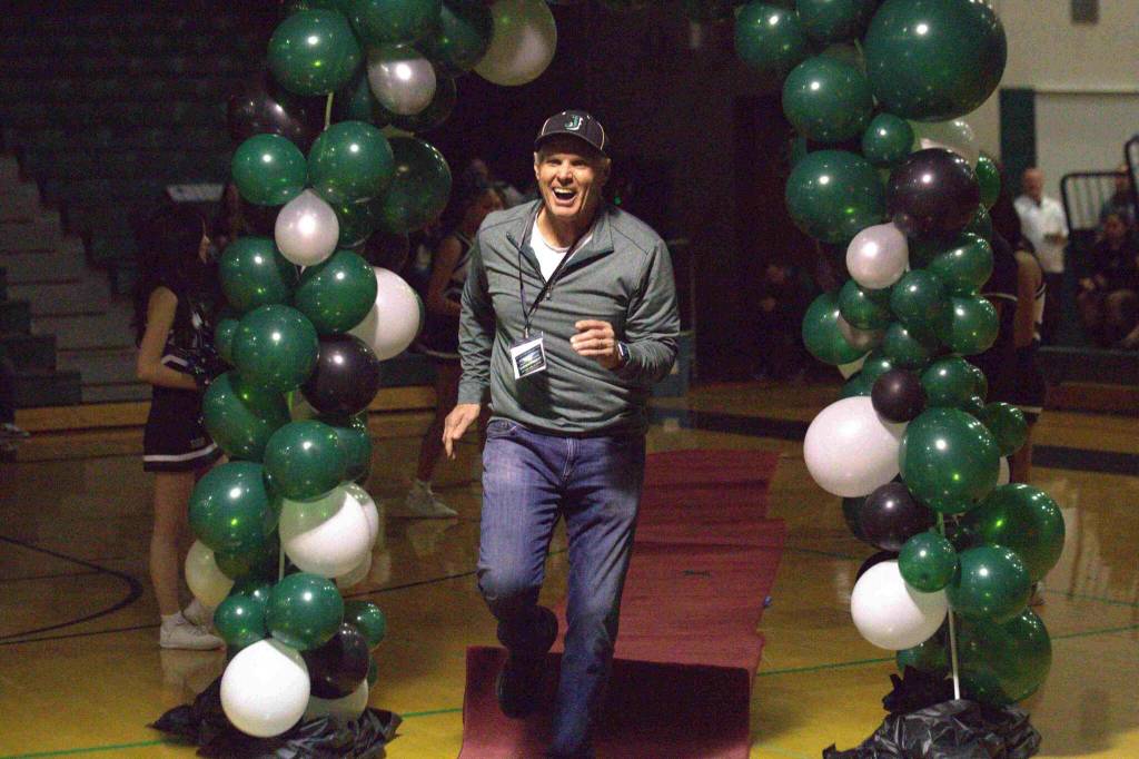 Alan Briggs, coach of the 2006 state-champion baseball team, jogs through the balloon arch at an Athletic Hall of Fame ceremony at Jackson High School in Mill Creek on Jan. 17. (Aaron Coe / The Herald)