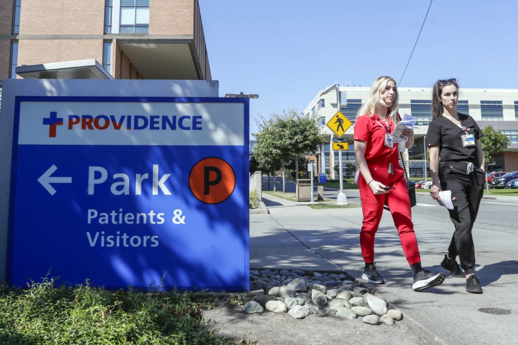 Members of the Providence nursing staff make their way to the rally Wednesday afternoon in Everett on Aug. 24, 2022. (Kevin Clark / The Herald)