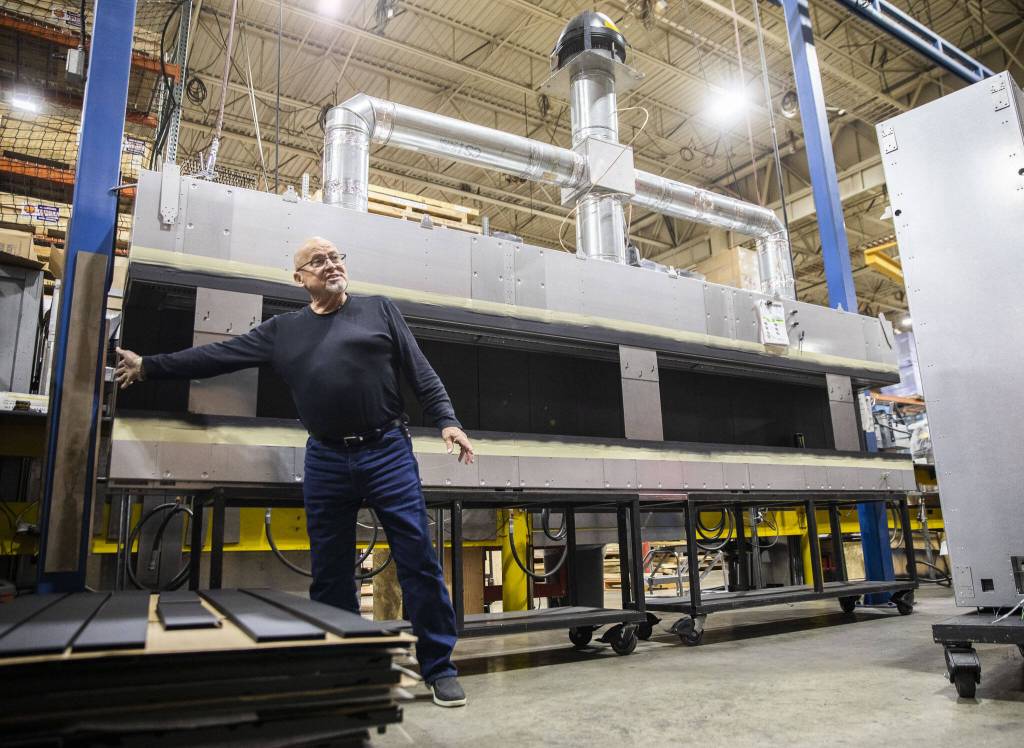 Kurt Rumens shows one of the large custom fireplaces Travis Industries is working on Thursday, Oct. 3, 2024 in Mukilteo, Washington. (Olivia Vanni / The Herald)