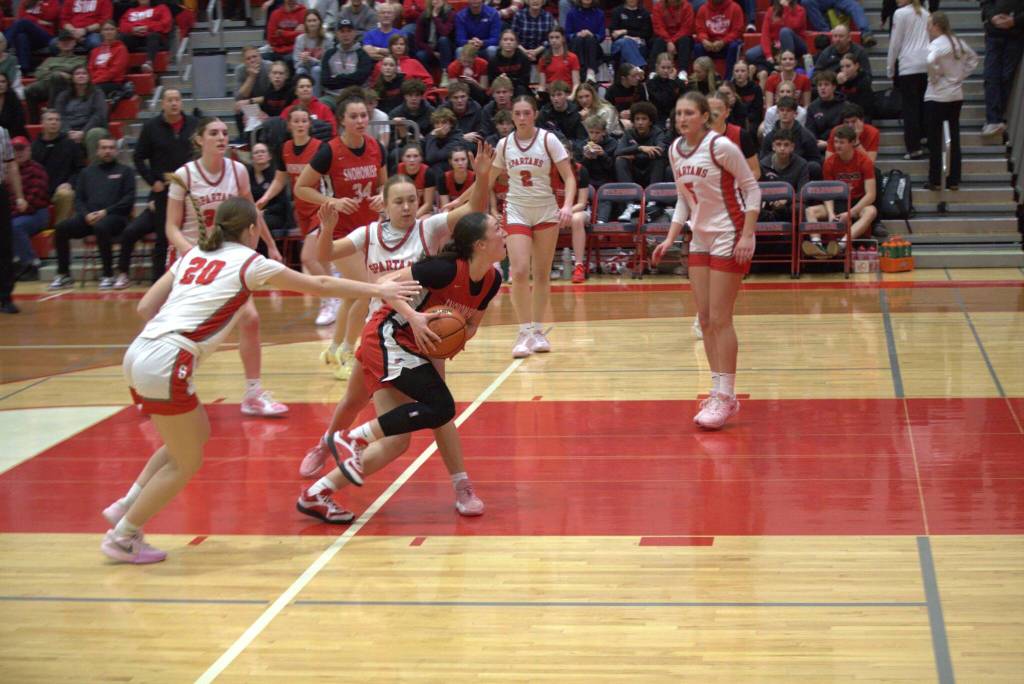 Snohomishs Sienna Capelli (13) drives to the basket against Stanwoods Presley Harris (20) in a Wesco 3A/2A game in Stanwood on Jan. 31, 2025. (Aaron Coe / The Herald)