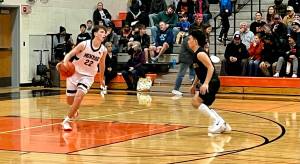 Monroe sophomore Isaiah Kiehl (22) brings the ball up court against Marysville Getchell senior Mariano Palacol to begin the second half in Monroe's 51-37 win on Jan. 31, 2025 (Joe Pohoryles / The Herald).