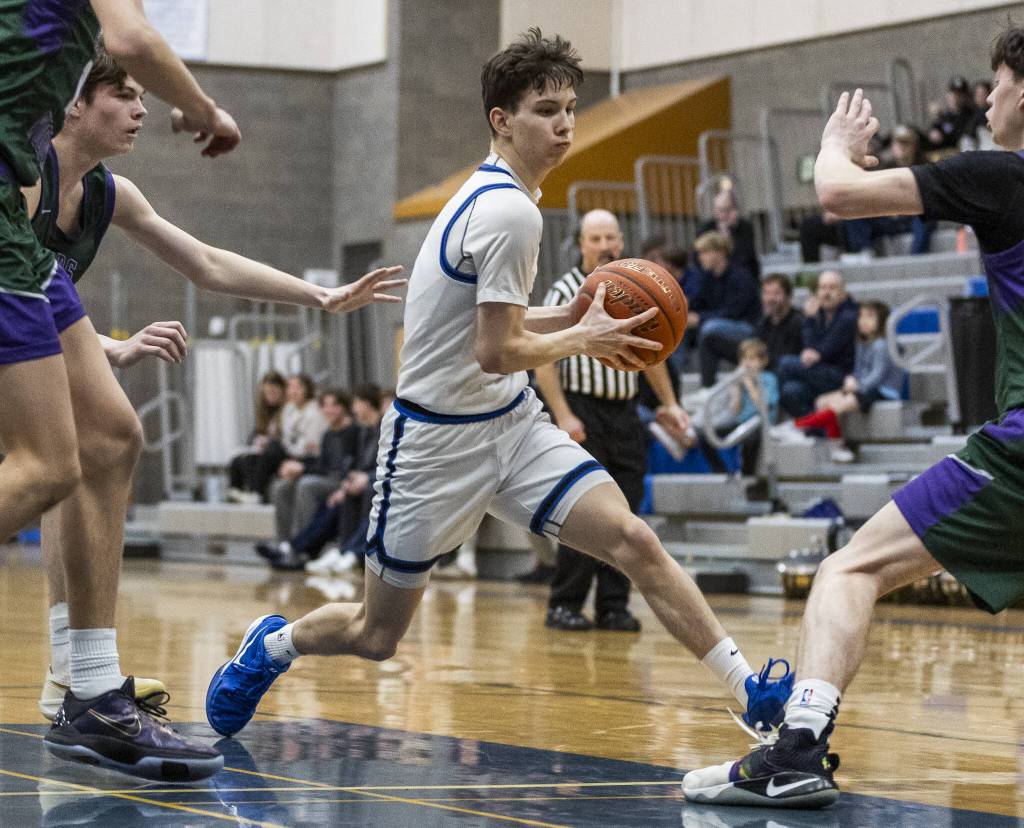 Shorewoods Thomas Moles tries to maneuver around multiple Edmonds-Woodway players for a clear path for a layup during the game on Tuesday, Feb. 4, 2025 in Shoreline, Washington. (Olivia Vanni / The Herald)