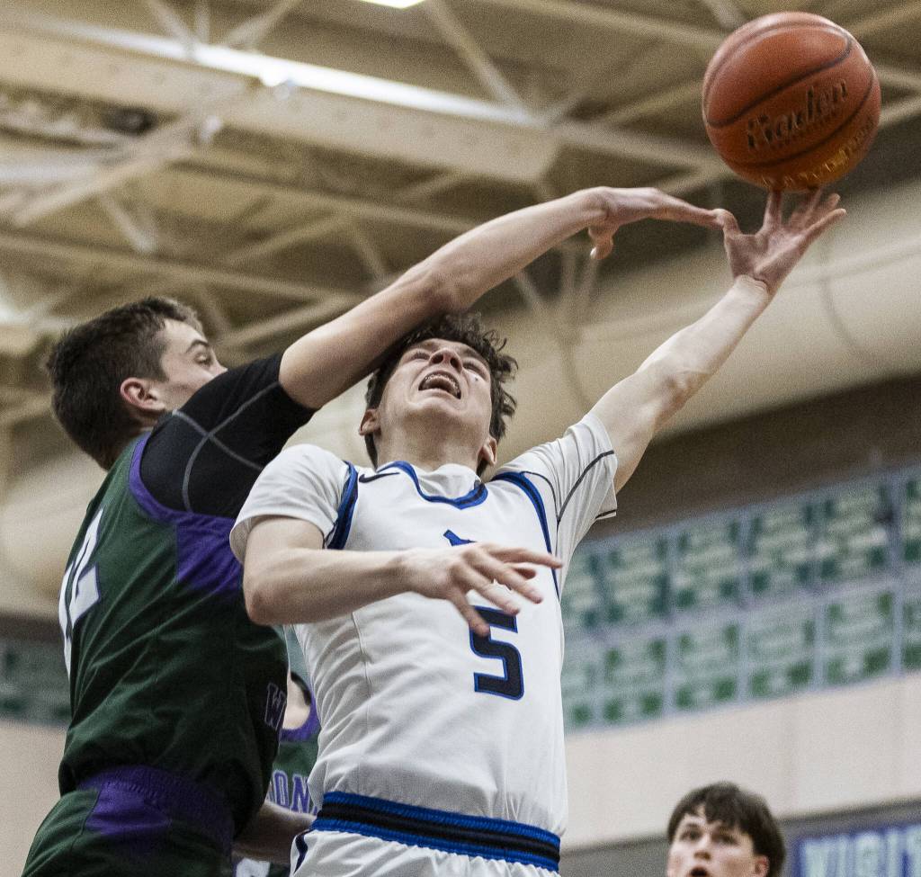 Edmonds-Woodways William Alseth knocks the ball out of the hands of Shorewoods Thomas Moles while he tries to make a layup during the game on Tuesday, Feb. 4, 2025 in Shoreline, Washington. (Olivia Vanni / The Herald)