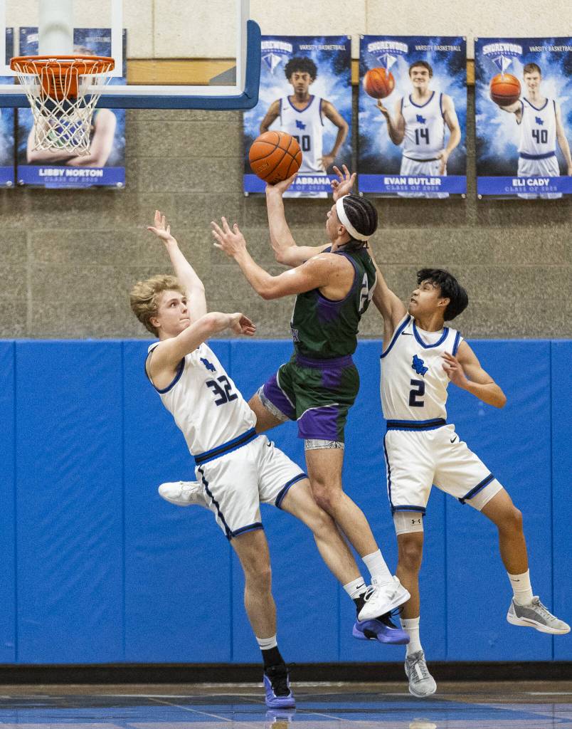 Shorewoods Elijah Haub and Kevin Cambronero try to block the layup attempt by Edmonds-Woodways Julian Gray during the game on Tuesday, Feb. 4, 2025 in Shoreline, Washington. (Olivia Vanni / The Herald)