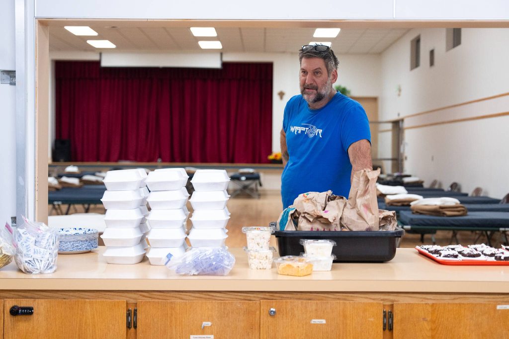 Timothy Evans stands near donated food on at the east Everett cold weather shelter on Tuesday, Feb. 11 in Everett, Washington. (Will Geschke / The Herald)