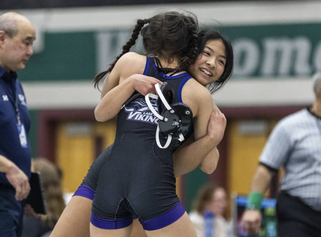 Lake Stevens Lily Ganal receives a hug from a teammate after beating Glacier Peaks Eliana Sherve in the 130-pound match at the 4A girls wrestling district tournament on Friday, Feb. 7, 2025 in Mill Creek, Washington. (Olivia Vanni / The Herald)