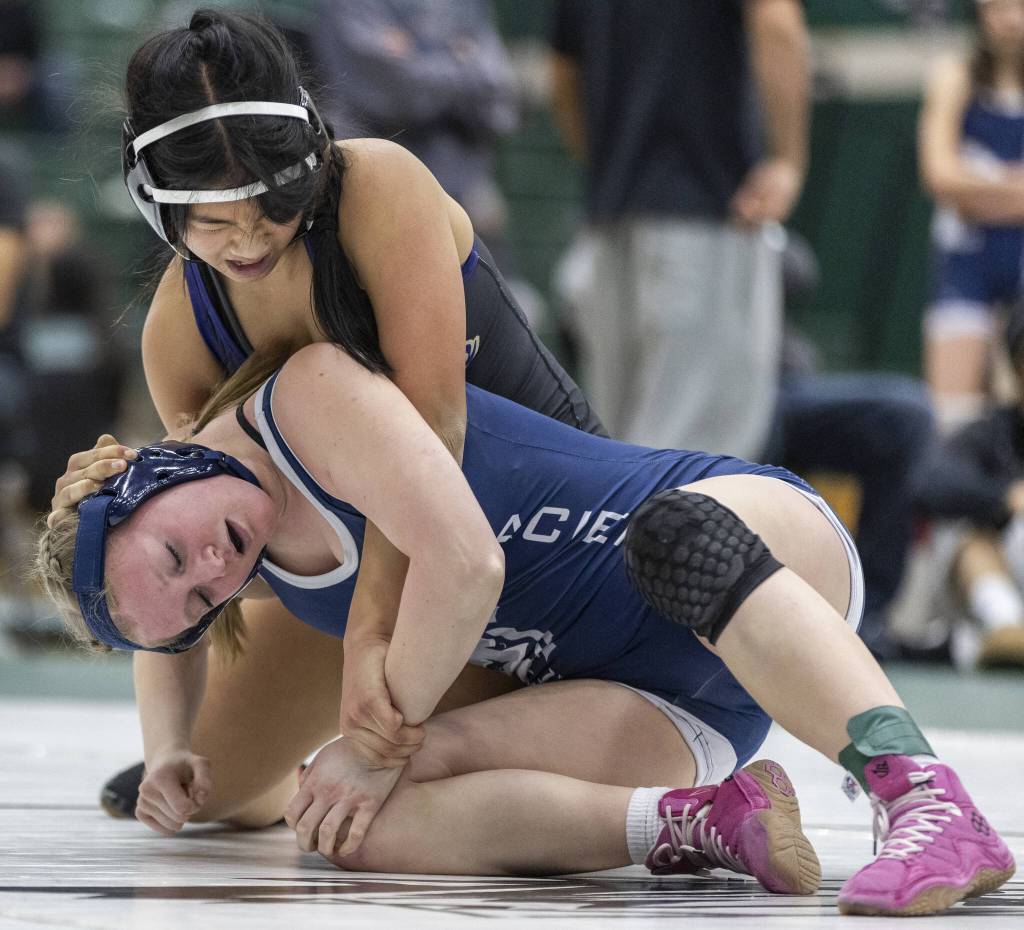 Lake Stevens Lily Ganal grimaces as she tries to get control of the wrist of Glacier Peaks Eliana Sherve during the 130-pound match at the 4A girls wrestling district tournament on Friday, Feb. 7, 2025 in Mill Creek, Washington. (Olivia Vanni / The Herald)