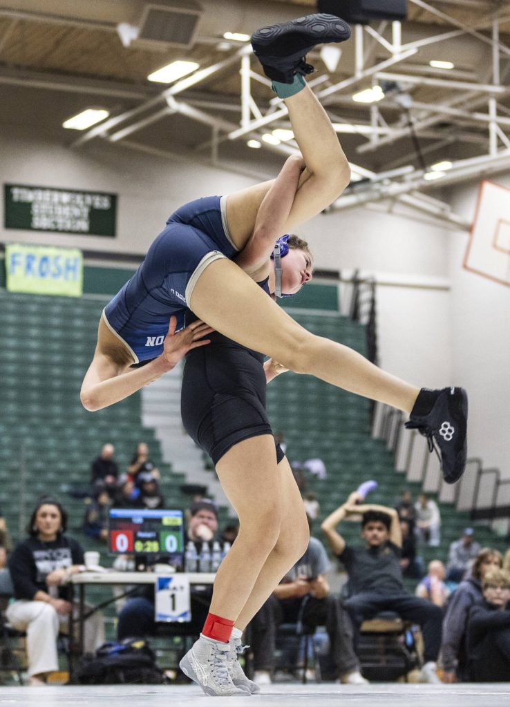Kamiaks Kai Burgess flips Arlingtons Jaymari ONeal over her back during the 125-pound match at the 4A girls wrestling district tournament on Friday, Feb. 7, 2025 in Mill Creek, Washington. (Olivia Vanni / The Herald)