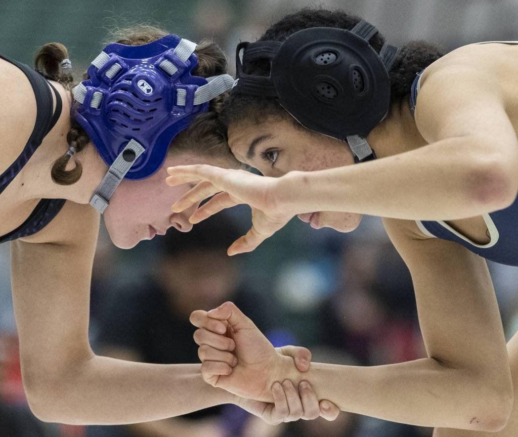 Kamiaks Kai Burgess and Arlingtons Jaymari ONeal hand fight during the 125-pound match at the 4A girls wrestling district tournament on Friday, Feb. 7, 2025 in Mill Creek, Washington. (Olivia Vanni / The Herald)