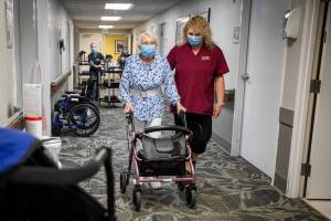 CNA Nina Prigodich, right, goes through restorative exercises with long term care patient Betty Long, 86, at Nightingale's View Ridge Care Center on Friday, Feb. 10, 2023 in Everett, Washington. (Olivia Vanni / The Herald)