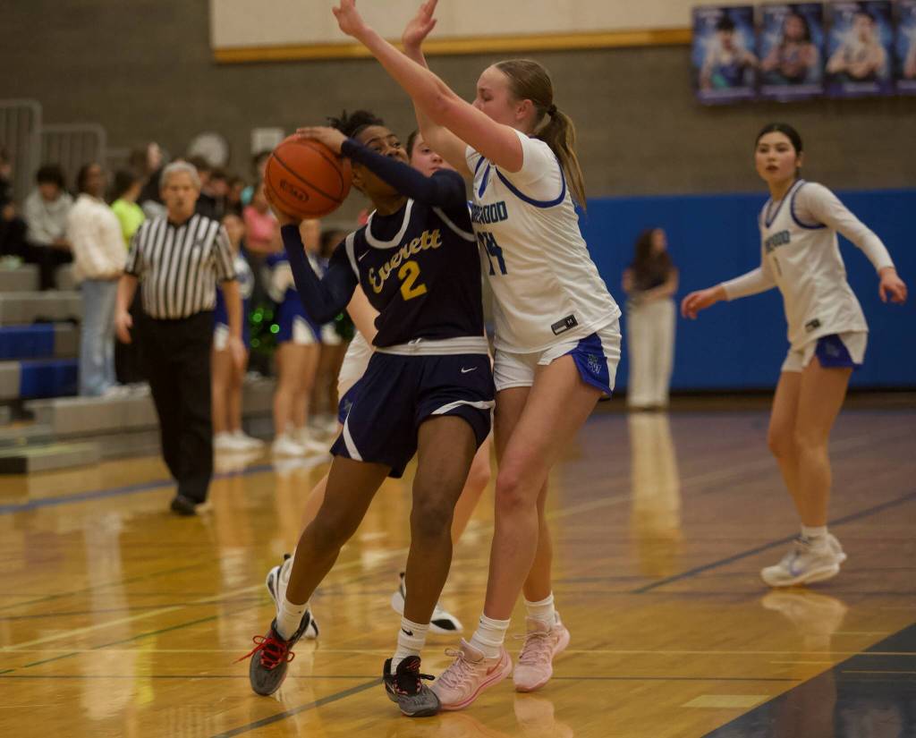 Everett junior Akilah Shaw (2) drives into Shorewood freshman Elle Wiehle (14) while contesting for a layup in Shorewood's 41-30 win in the opening round of the District 1 3A Girls Tournament on Wednesday, Feb. 12, 2025 in Shoreline, Washington. (Joe Pohoryles / The Herald)