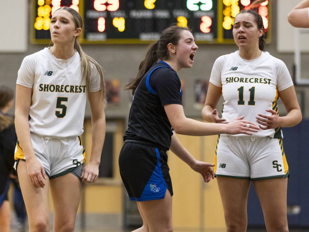 Shorewoods Bridget Cox yells in celebration of a foul call while Shorecrests Anna Usitalo and Naima Preudhomme look at the referees in confusion during the 3A district playoff game on Friday, Feb. 14, 2025 in Shoreline, Washington. (Olivia Vanni / The Herald)