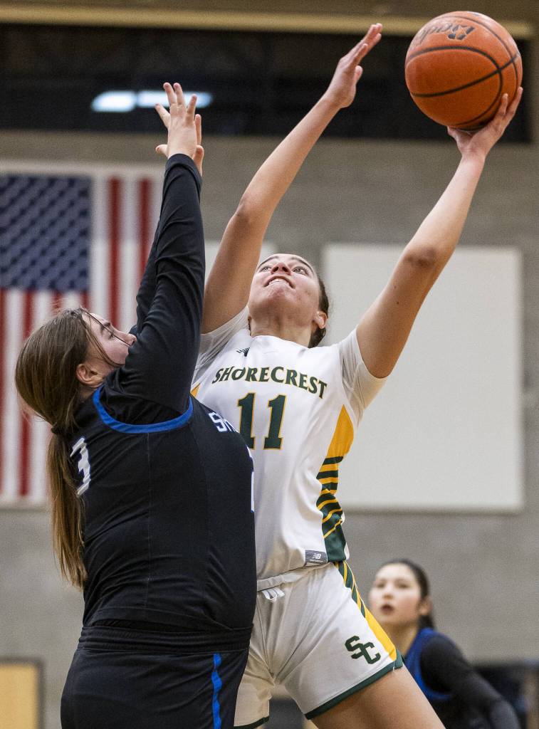Shorecrests Naima Preudhomme makes a layup over the outstretched arms of Shorewoods Rylie Gettmann during the 3A district playoff game on Friday, Feb. 14, 2025 in Shoreline, Washington. (Olivia Vanni / The Herald)