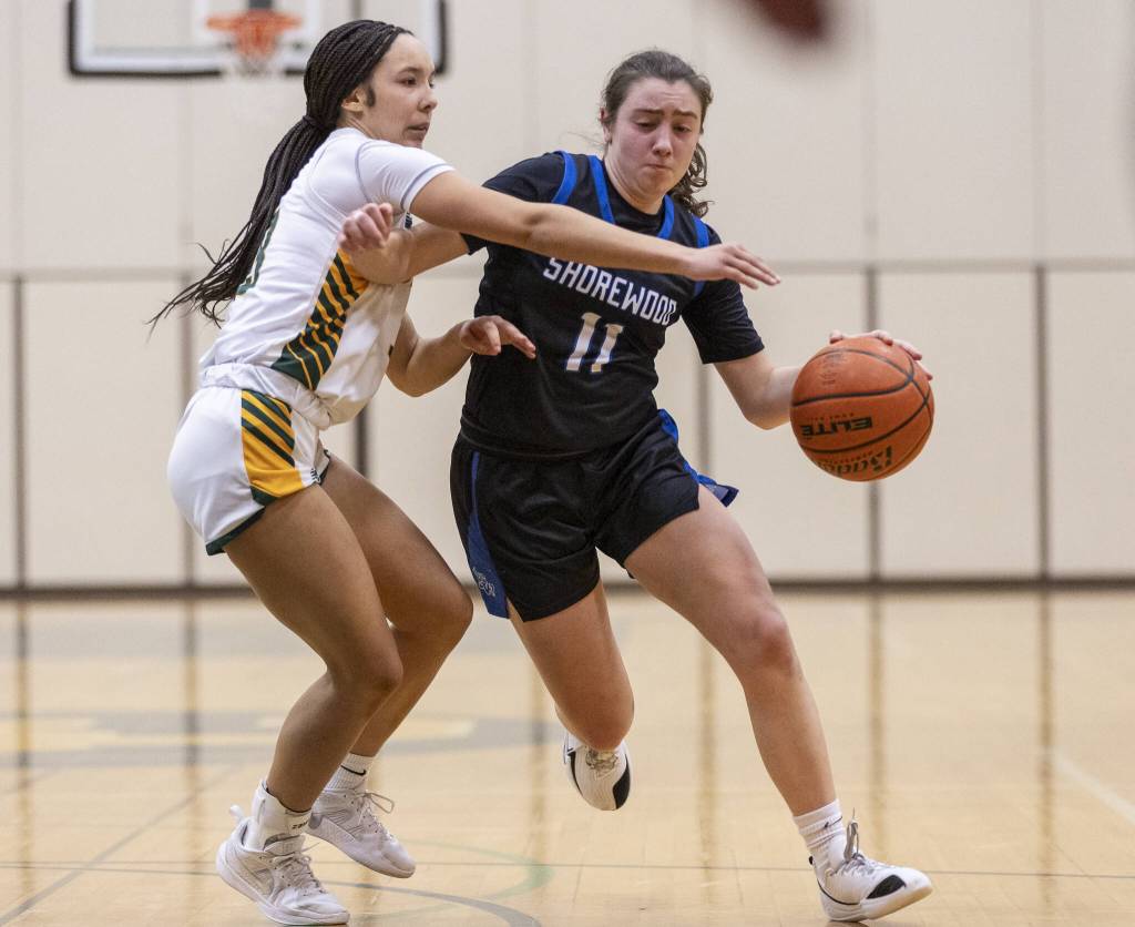 Shorewoods Bridget Cox attempts to dribble around Shorecrests Acacia Silimon during the 3A district playoff game on Friday, Feb. 14, 2025 in Shoreline, Washington. (Olivia Vanni / The Herald)
