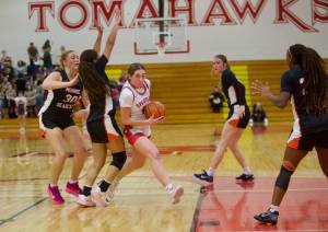 Stanwood junior Ellalee Wortham (2) lunges toward the basket past several Monroe defenders to attempt an underhand layup in the Girls 3A Basketball District 1 semifinals at Marysville Pilchuck High School in Marysville, Washington on Feb. 18, 2025. Wortham scored 33 points in the 59-41 win for the Spartans, eclipsing 1,000 career points. (Joe Pohoryles / The Herald)