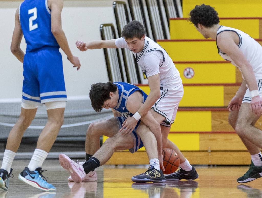 Shorewoods Jaden Marlow and Edmonds-Woodways William Alseth scramble for a loose ball during the 3A district semifinal game on Wednesday, Feb. 19, 2025 in Marysville, Washington. (Olivia Vanni / The Herald)