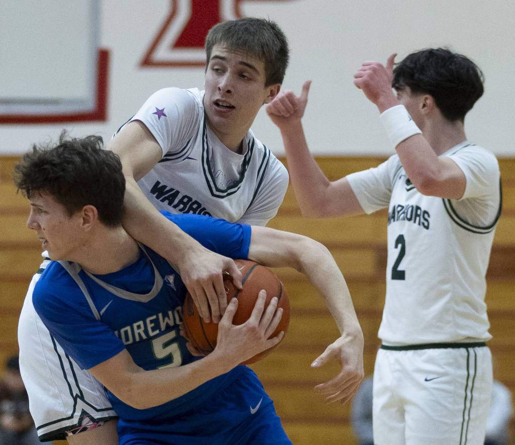 Shorewoods Thomas Moles and Edmonds-Woodways William Alseth look to the referees for a jump ball call during the 3A district semifinal game on Wednesday, Feb. 19, 2025 in Marysville, Washington. (Olivia Vanni / The Herald)