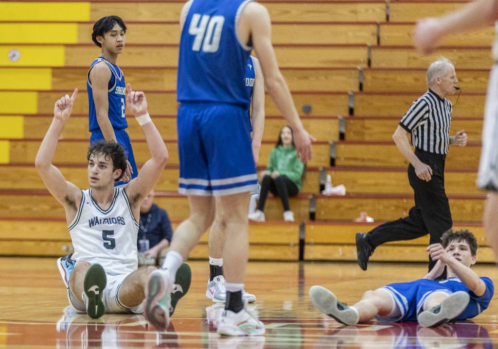 Edmonds-Woodways Cam Hiatt puts his fingers up in the air in celebration after hitting a half-court shot at the halftime buzzer during the 3A district semifinal game against Shorewood on Wednesday, Feb. 19, 2025 in Marysville, Washington. (Olivia Vanni / The Herald)