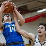 Edmonds-Woodways Cam Hiatt grimaces as his arm gets tangled with Shorewoods Evan Butler for a rebound during the 3A district semifinal game on Wednesday, Feb. 19, 2025 in Marysville, Washington. (Olivia Vanni / The Herald)