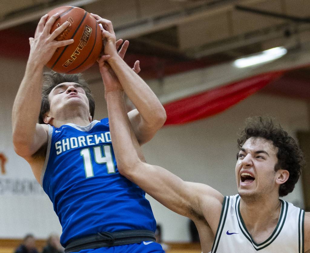 Edmonds-Woodways Cam Hiatt grimaces as his arm gets tangled with Shorewoods Evan Butler for a rebound during the 3A district semifinal game on Wednesday, Feb. 19, 2025 in Marysville, Washington. (Olivia Vanni / The Herald)
