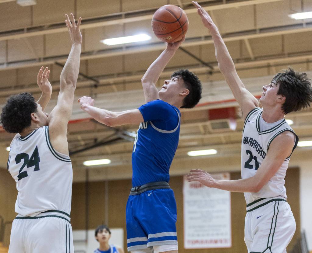 Edmonds-Woodways Julian Gray and Luke Boland both reach up to try and block a shot by Shorewoods Max Nguyen during the 3A district semifinal game on Wednesday, Feb. 19, 2025 in Marysville, Washington. (Olivia Vanni / The Herald)