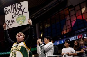A Seattle Sonics fan holds a sign before the Rain City Showcase in a preseason NBA game between the LA Clippers and the Utah Jazz at Climate Pledge Arena on Oct. 10, 2023, in Seattle. (Steph Chambers / Getty Images / Tribune News Services)