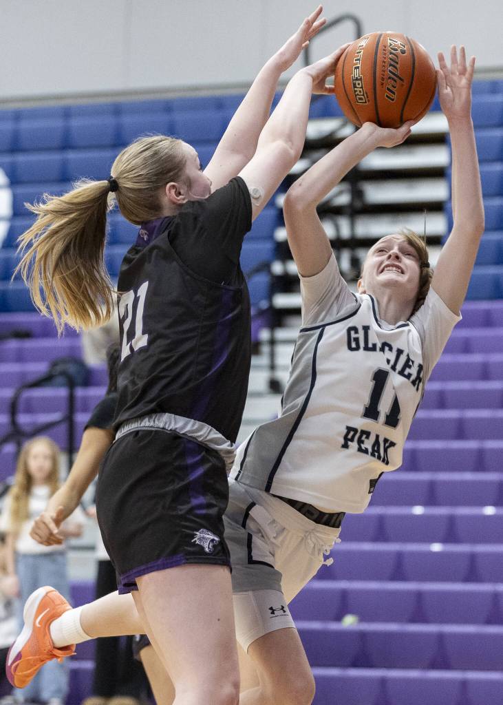 Glacier Peaks Zoey Ritter falls while shooting during the 4A district loser-out playoff game against North Creek on Thursday, Feb. 20, 2025 in Kirkland, Washington. (Olivia Vanni / The Herald)